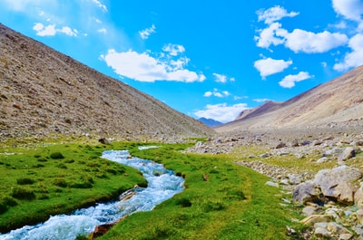 Under the blue sky during the day the brown mountains between the rivers
